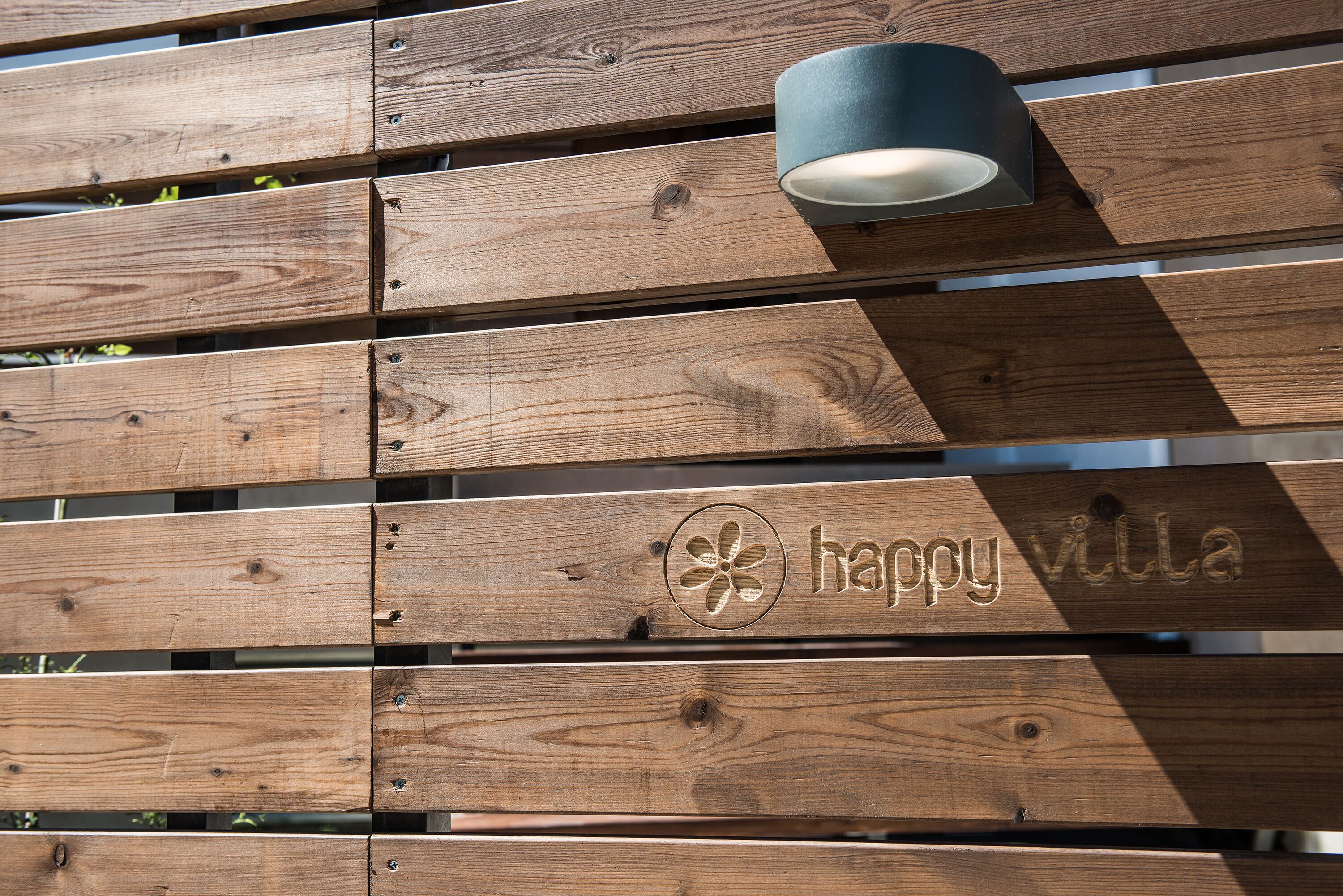 A wooden wall with horizontal planks and a mounted light fixture.