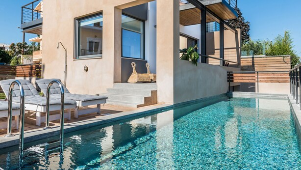 Une maison moderne dotée d’une piscine, d’un balcon et d’un escalier menant à l’étage supérieur.