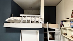 A compact room with a bunk bed, a ladder, a bookshelf, and a door. - Home WIFI & Compact & Tranquil Apt with LOFT! (杉並区)