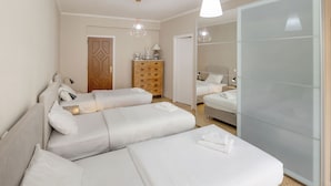 A hotel room with two beds, a wardrobe, a dresser, and a mirror. - Leonidas Loft in the Heart of Athens by GHH (Athens)