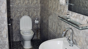 A bathroom with a marble sink, a toilet, and a mirror. - Kathmadu Fawlty Home (Kathmandu)