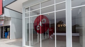 Une devanture de magasin avec de grandes vitrines et un logo rouge circulaire bien visible.