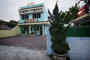 A two-story building with a sign reading "PENINJAPAN" and a large tree in the foreground. - OYO 796 Penginapan Fergael (Pematangsiantar)