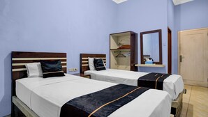 Une chambre d’hôtel avec deux lits, une armoire, un miroir et une porte.