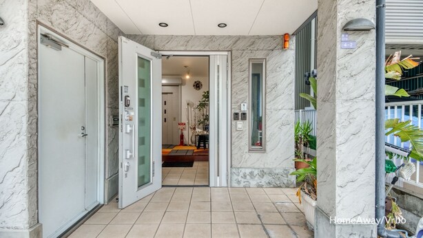 Entrada de hotel con piso y paredes de mármol, puerta de vidrio y un cartel que indica la habitación número 4-2.