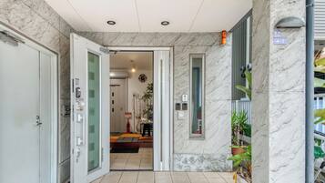 A hotel entrance with a marble floor and walls, a glass door, and a sign indicating room number 4-2.