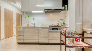 Una cocina moderna con una isla central, electrodomésticos integrados y un comedor con mesa de madera.