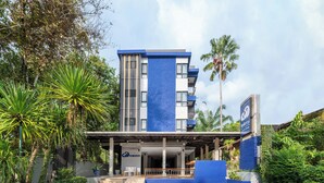 Um edifício moderno com fachada azul e branca, entrada coberta e placa com o nome 'kokotel'.