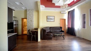 Un salon avec un canapé, une table basse, un téléviseur et une cheminée.