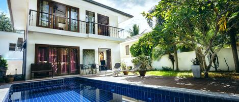 Een buitenzwembad en ligstoelen