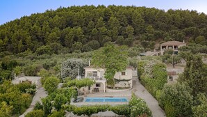 A hillside villa with a swimming pool, surrounded by lush greenery and a forested backdrop. - Villa Natura  Private pool and Sea view -early book 60dates or more 5%  DISCOUNT (Λιθακιά)