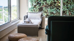 A room with a bed, a chair, and two woven ottomans on a tiled floor. - Villa Natura  Private pool and Sea view -early book 60dates or more 5%  DISCOUNT (Λιθακιά)
