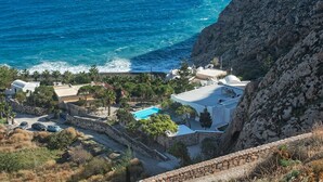 A coastal property with a swimming pool, stone walls, and a view of the sea. - Villa Adrali, 4 bedrooms, private pool (ΘΗΡΑ)