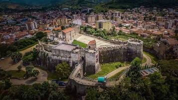 Vista aerea di un castello storico circondato da un panorama urbano.