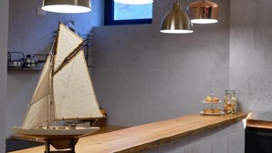 A model sailboat on a wooden counter with pendant lighting above. - La Via Del Porto (Agropoli)