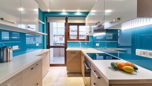 A modern kitchen with a central island, built-in appliances, and a view to the outside. - Modern Apartment, just 70 meters from the sea! (Ρέθυμνο)