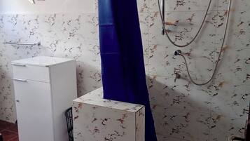 Une salle de bain avec une douche, un meuble blanc et un porte-serviettes.