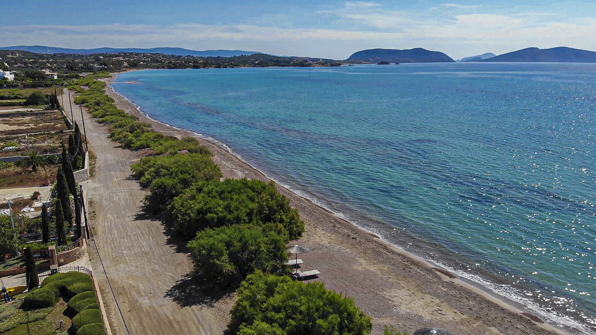 En la playa, sillas reclinables de playa, sombrillas, toallas de playa