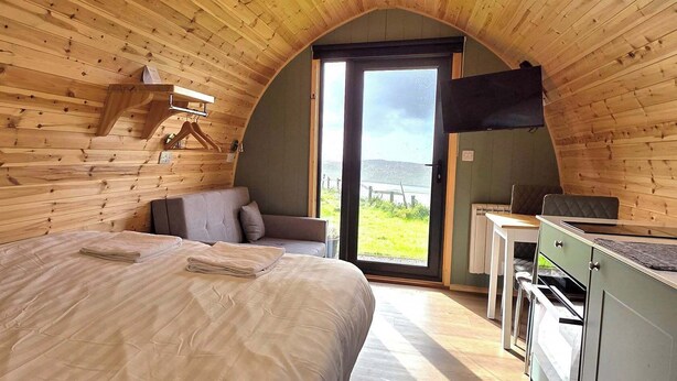 A cozy room with a bed, a sofa, a table, and a TV. - The Westings (Whiteness)