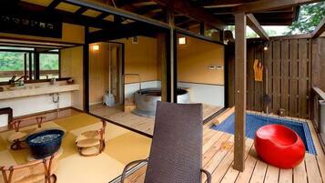 Une pièce de style japonais traditionnel, avec un sol recouvert de tatamis, un plafond en bois et un espace détente aux couleurs rouge.