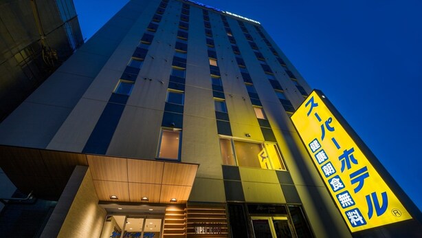 A modern hotel building with a prominent yellow sign indicating a restaurant on the ground floor. - Super Hotel Hachinohe Nagayokocho (Hachinohe)