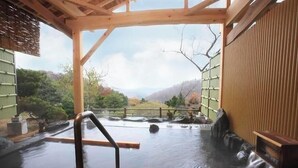 A hot spring bath area with wooden beams, a wooden bench, and a view of the surrounding landscape. - Aone Onsen Sankei no Yado Ryusen (Kawasaki)