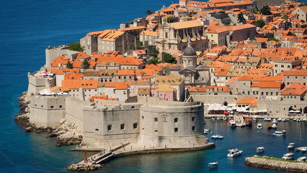 A coastal town with historic buildings, a prominent fortification, and a marina with boats. - Villa Lucia (dubrovnik)