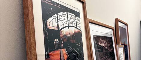 A wall with framed pictures of a tram and a building.