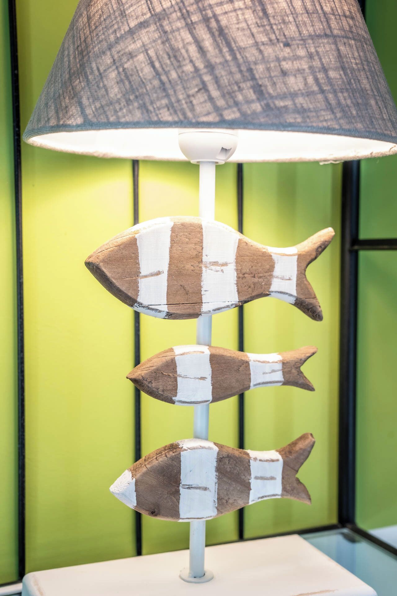 A lamp with a fish-shaped base and a textured lampshade.