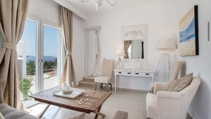 A spacious room with a large window, a wooden table with a tray, a white desk, and a comfortable chair. - Villa Sofia, The Best SeaView Of Naxos (Νάξος)