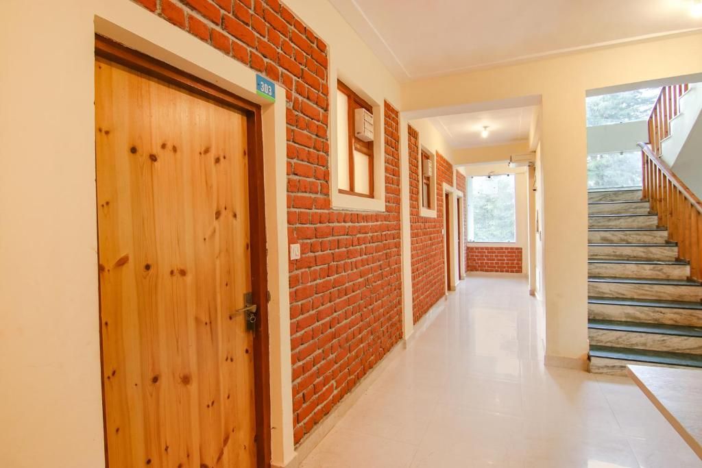 Un couloir avec des portes en bois, des murs en briques et un escalier en marbre.