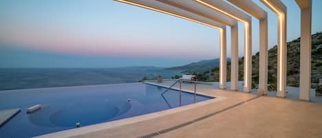 Een buitenzwembad, ligstoelen bij het zwembad