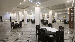 A spacious indoor area with multiple tables and chairs, a polished floor, and a high ceiling with recessed lighting. - Marc Royal (Agra)