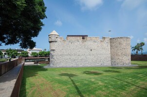 Une structure en pierre qui ressemble à un château, avec une pelouse devant.