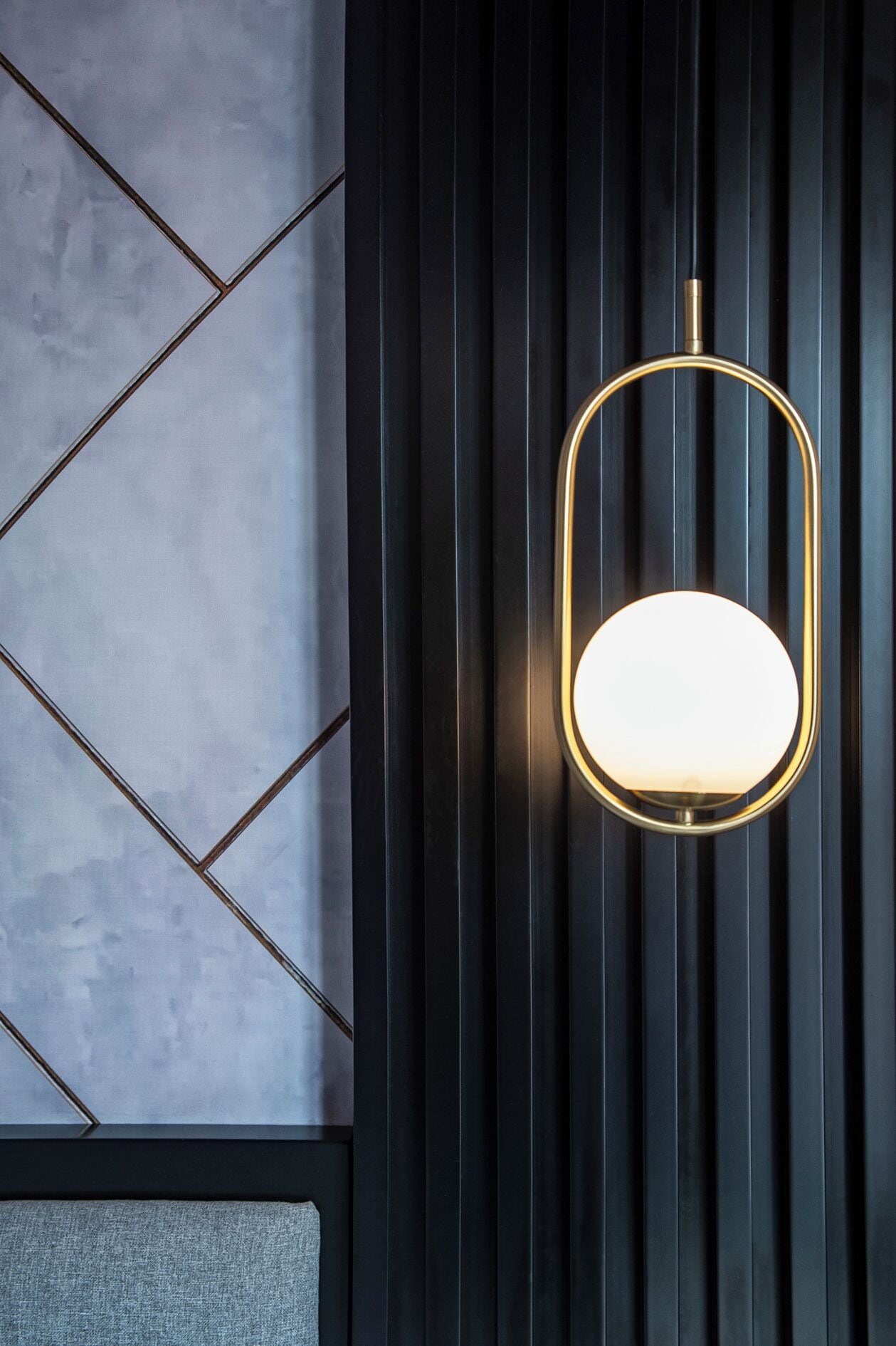 A modern interior with a geometric patterned wall and a wall-mounted light fixture.
