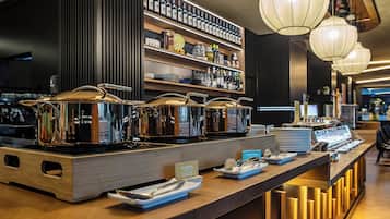 Un espace buffet doté de plusieurs points de service, dont un espace intitulé « HUEVOS » pour les œufs, et une variété de bouteilles et de bocaux disposés sur des étagères à l’arrière-plan.