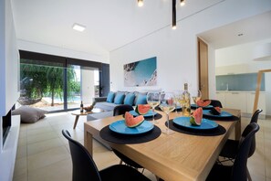 Un comedor moderno con una mesa de madera, platos azules y rebanadas de sandía.