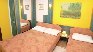 Una habitación con dos camas, un espejo y un cuadro en la pared.