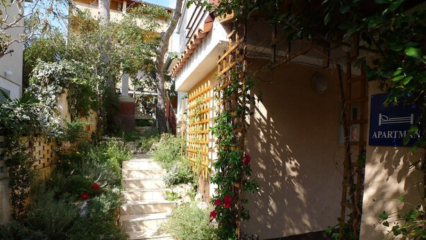 Un sendero estrecho que conduce a un edificio con un cartel que indica que es un apartamento.