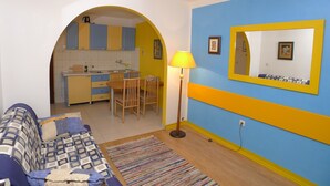 Un espacio habitable compacto con cocina, comedor y sofá.