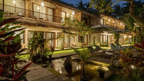 A hotel with multiple balconies, a pool area, and lush tropical plants. - Kandarpa Ubud (Ubud)