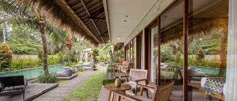 An outdoor seating area with wooden furniture, a small table, and a bench.