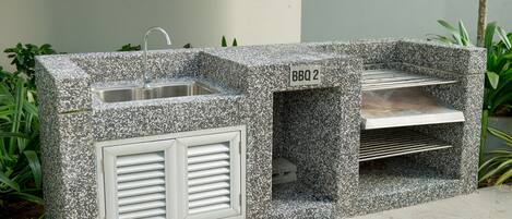 Un angolo barbecue in pietra con lavandino e griglie di ventilazione, con l'indicazione 'BBQ 2'.