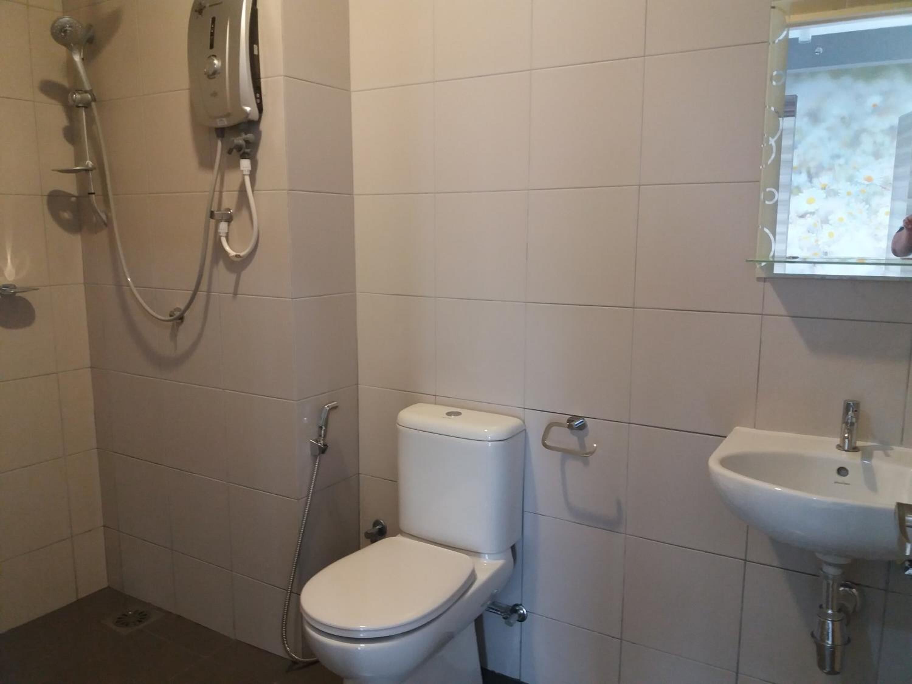 Une salle de bain avec des toilettes, une douche et un lavabo.
