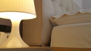 A neatly made bed with a headboard, a bedside lamp, and a wooden nightstand. - Cozy Flat near Athens City Center (Athens)