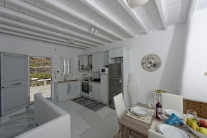 A modern kitchen with white cabinetry, a built-in microwave, and a stainless steel refrigerator. - Traditional 5-Star Reviews Sea View Villa With Private Pool (Μύκονος)