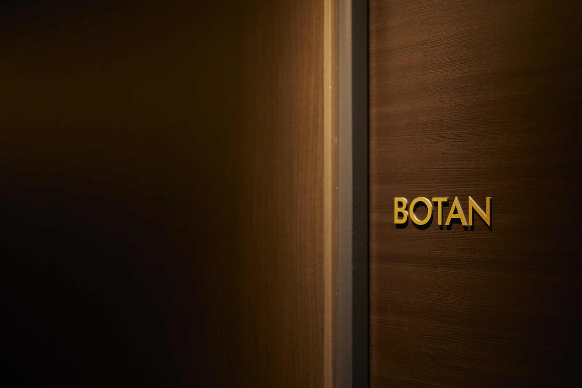 A wooden door with the word 'BOTAN' in gold lettering.