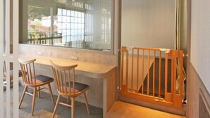 A room with a wooden desk, two chairs, a window with a view, and a wooden railing. - Myoken Onsen Nemu (Kirishima)