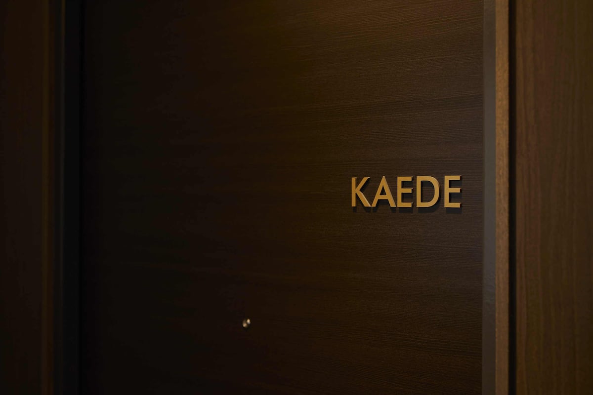 A wooden door with the name 'KAEDEN' in gold lettering.