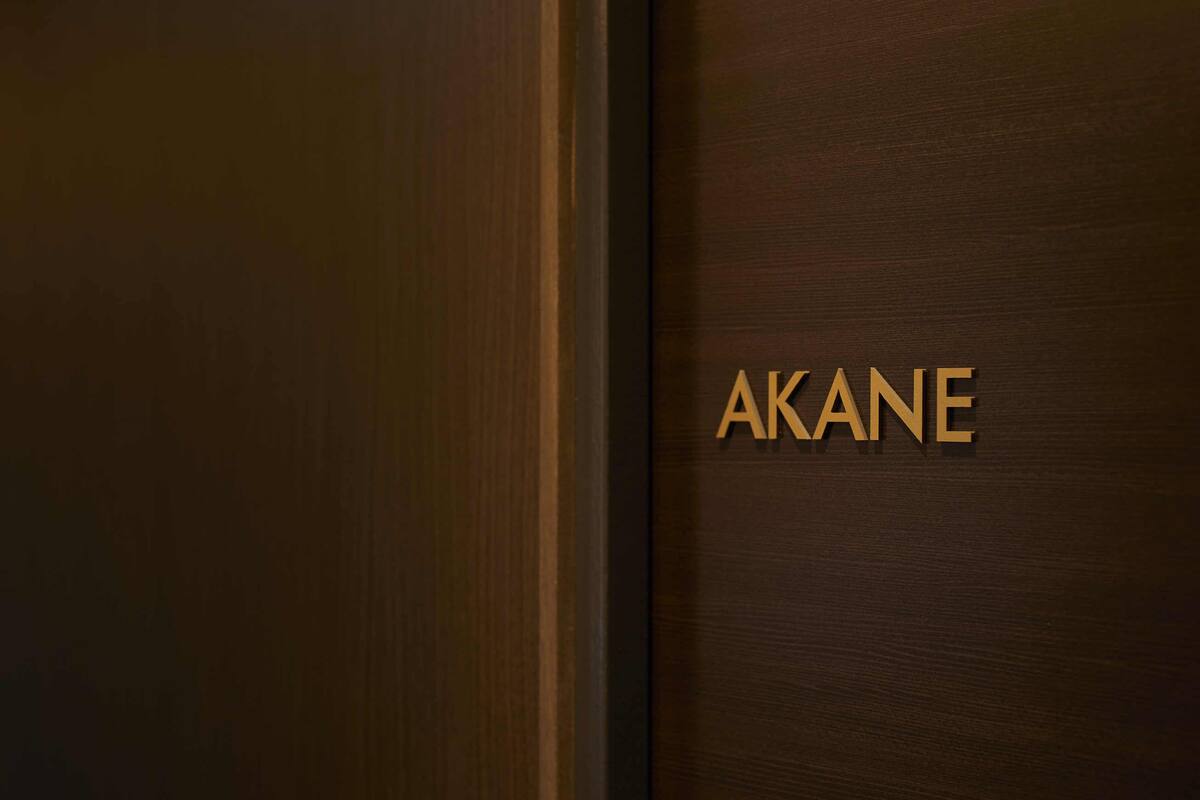 A wooden door with the name 'AKANE' in gold lettering.